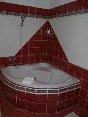 a bath tub in a red tiled bathroom at Motel U Krbu in Vestec