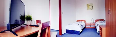 a room with a tv and a desk with a bed at Hotel S-centrum in Benešov