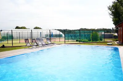 a swimming pool with two chairs and a fence at Hotel S-centrum in Benešov