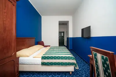 a bedroom with a bed with a blue wall at Hotel Czechia in Prague