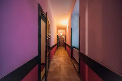 a hallway with pink and purple walls and doors at Hotel Czechia in Prague