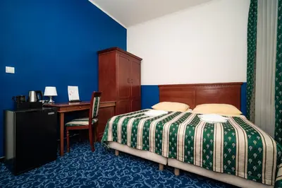 a bedroom with a bed and a desk with a computer at Hotel Czechia in Prague