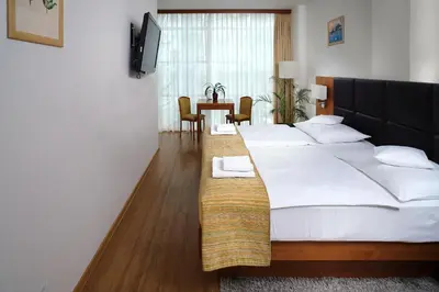 a bedroom with a large bed and a table and chairs at Hotel Ankora in Prague