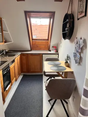 a kitchen with a table and two chairs and a window at Apartman Mala Strana -Piece and quiet in Prague