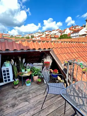 a deck with a table and chairs and plants at Apartman Mala Strana -Piece and quiet in Prague