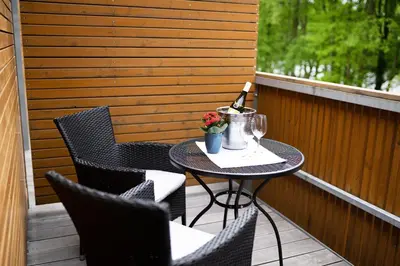 a small table on a balcony with chairs and a blender at Penzion Labska Marina in Poděbrady