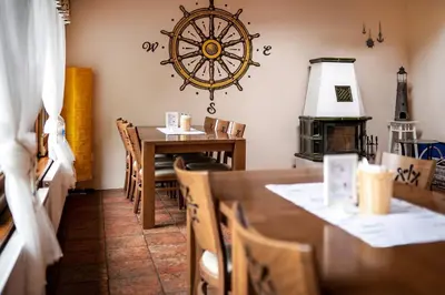 a dining room with a table and a clock on the wall at Penzion Labska Marina in Poděbrady