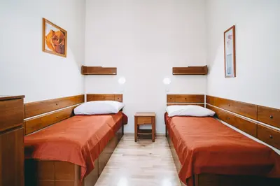 two beds are in a room with white walls at Hotel Dar in Prague