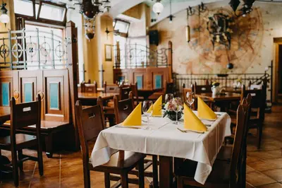 a dining room with tables and chairs with yellow napkins at Hotel Dar in Prague