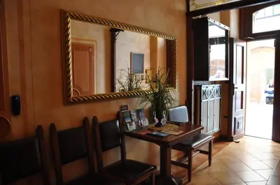 a mirror on the wall of a room with a table at Hotel Dar in Prague