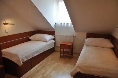 two beds in a small room with a window at Hotel Dar in Prague