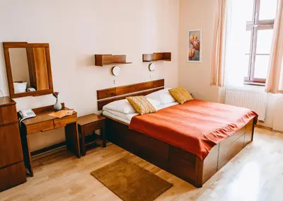 a bedroom with a bed with a desk and a mirror at Hotel Dar in Prague