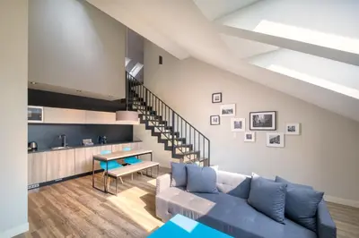 a living room with a blue couch and a staircase at Avenue Legerova 19 in Prague