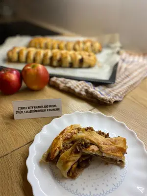 a piece of pie on a plate on a table with apples at Bohem Prague Hotel in Prague