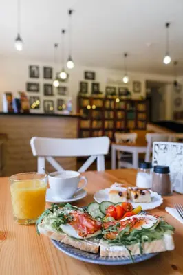 a table with a plate of food and a glass of orange juice at Bohem Prague Hotel in Prague