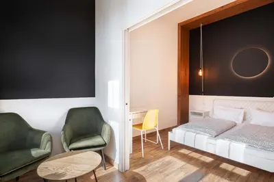 a bedroom with a bed and a desk and chairs at Bohem Prague Hotel in Prague