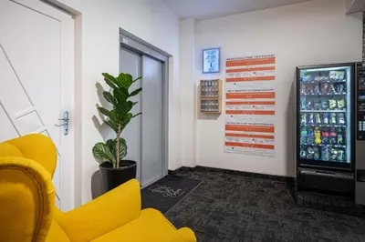 a waiting room with a yellow chair and a soda machine at Bohem Prague Hotel in Prague