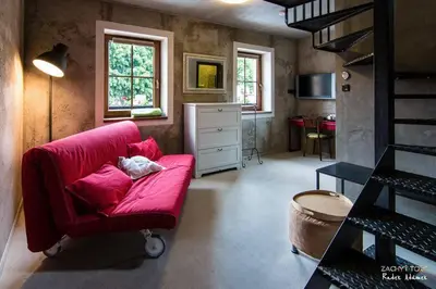 a living room with a red couch and a dresser at Penzion Čokolaterie in Třebenice