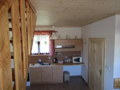 a kitchen with wooden cabinets and a counter top at Rekreacni Dum Brdy in Ohrazenice