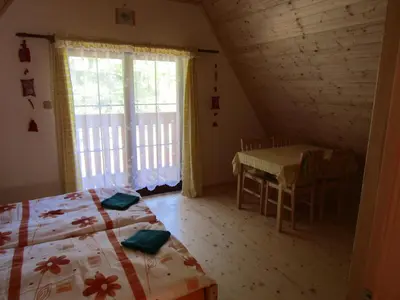 a bedroom with a bed and a table and a window at Rekreacni Dum Brdy in Ohrazenice