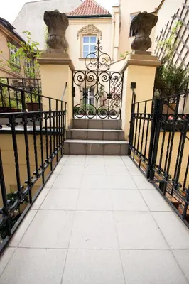 a gate in front of a house with a staircase at Hotel U Zlateho jelena in Prague