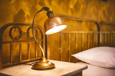 a lamp sitting on a table next to a bed at Hotel U Zlateho jelena in Prague