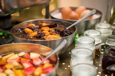 two pans of food on a table with fruits and vegetables at Hotel U Zlateho jelena in Prague