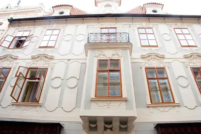 a white building with windows and a balcony at Hotel U Zlateho jelena in Prague