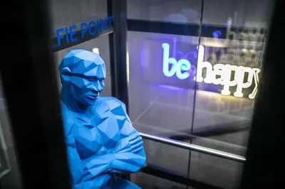 a blue figurine sitting in front of a window at MeetMe23 in Prague
