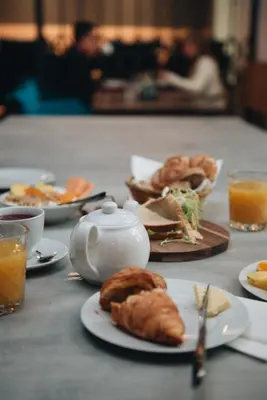a table with plates of food and a teapot at MeetMe23 in Prague
