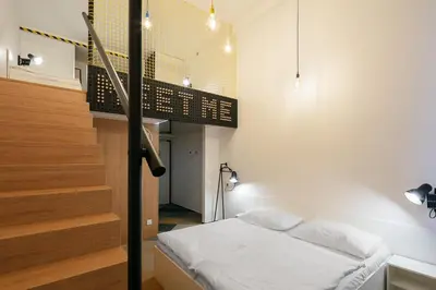 a bedroom with a bed and a stair case at MeetMe23 in Prague