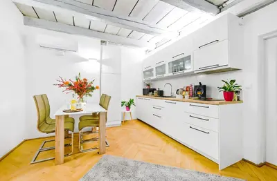 a kitchen with white cabinets and a table and chairs at Royal Route Residence in Prague