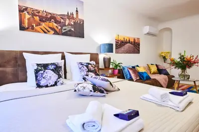 a bedroom with two beds and a couch at Royal Route Residence in Prague