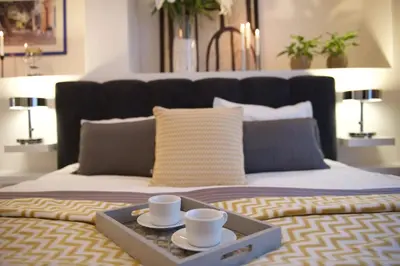 a tray with two cups and plates on a bed at Royal Route Residence in Prague