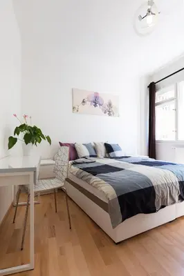 a white bedroom with a bed and a desk at Hanan's Benedikt in Prague