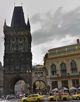 two yellow taxis in front of a building with a clock tower at Hanan's Benedikt in Prague