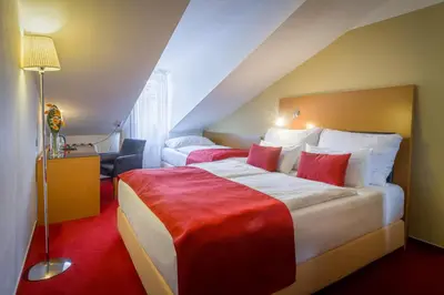 a hotel room with a large bed with red sheets at Theatrino Hotel in Prague