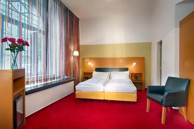 a hotel room with a bed and a chair at Theatrino Hotel in Prague