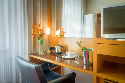 a hotel room with a desk with a television and chairs at Theatrino Hotel in Prague