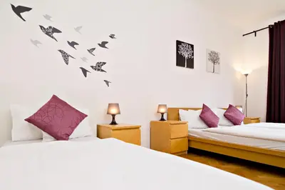 a bedroom with two beds and purple pillows at Apartments with 2 Bathrooms in Prague