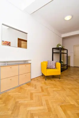 a living room with a yellow chair and a mirror at Apartments with 2 Bathrooms in Prague