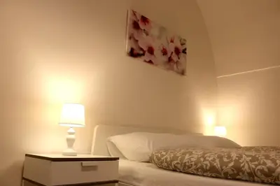 a bedroom with a bed and a table with a lamp at Betlem Prague Apartments in Prague