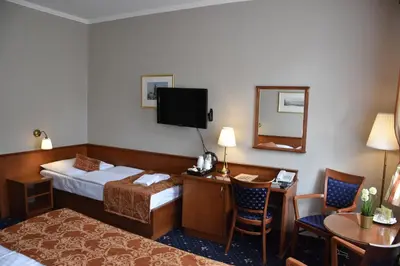 a hotel room with a bed and a desk and a mirror at Arbes in Prague