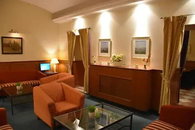 a lobby with a waiting room with orange chairs and a podium at Arbes in Prague