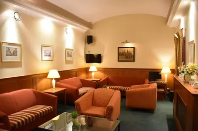 a waiting room with couches and chairs and a tv at Arbes in Prague