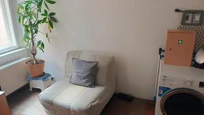 a white chair with a pillow in a living room at Park View - a digital Nomad's dream in Prague