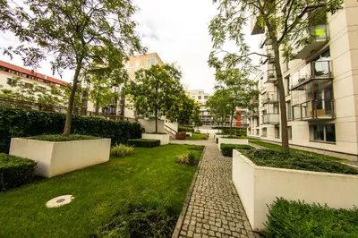 a courtyard in a building with trees and grass at Apartment Korunni Dvur 130m2, 2 Free Parkings in Prague