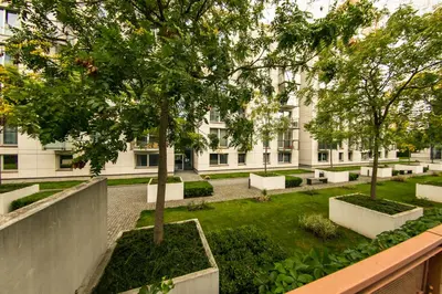 a courtyard with a tree in front of a building at Apartment Korunni Dvur 130m2, 2 Free Parkings in Prague