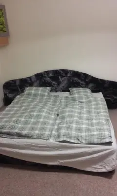 a bed with a green and white plaid pillow on it at flat 18 minutes from Vaclavske namesti in Prague