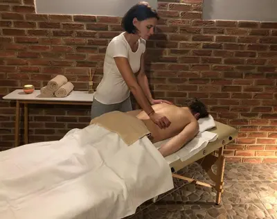 a woman giving a man a massage on a bed at Pension Viktorin in Poděbrady